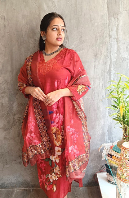 Model wearing rust red cotton silk straight kurti set with matching pants and floral dupatta 